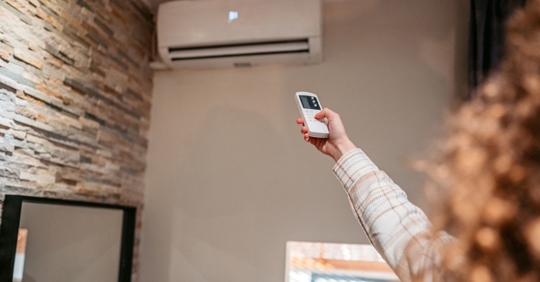 Woman turning on a ductless mini-split unit